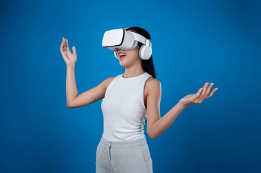 Mavi arka planı olan zeki bir kadın metaevrene bağlı VR kulaklık takıyor, gelecekçi siber uzay topluluğu teknolojisi. Zarif bir kadın sanal bir manzara gördüğü için heyecanlı. Halüsinasyon.