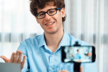 Etkilendiricinin sunucu kanalı akıllı telefon ile bulanık görüntü kullanır, satış ve pazarlama planlamasında çevrimiçi yayın yapar, modern ev ofisteki sosyal medya portresi üzerine odaklanır. Toplayıcı.