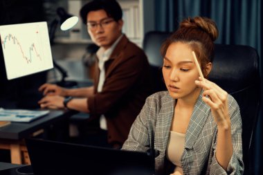 Modern ofiste gece geç saatlerde arka tarafta çalışan iş arkadaşı ile birlikte veri analizi sosyal medya çevrimiçi proje işini rapor etmek için bilgisayara odaklanan iş kadınının ciddi yüzü. İnfobahn.