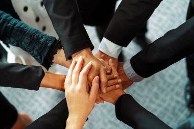 Birçok mutlu iş adamı neşe ve başarıyla el ele tutuşuyor. Şirket çalışanı başarılı bir iş projesini bitirdikten sonra kutlama yapıyor. Şirket ortaklığı ve başarı kavramı. uds
