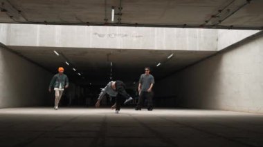 Dansçılar dans ederken bir grup hippi dondurucu poz veriyor. Profesyonel break dansçı takımı eğlenceli ve hareketli bir şekilde sokak dansı yapıyor. Açık hava sporu 2024. Yumuşak bir şekilde..