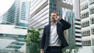 Yetenekli bir iş adamı pazarlama ekibiyle pazarlama stratejisi hakkında konuşurken gökdelende dururken telefon kullanıyor. Mutlu yönetici, modern kentsel şehirdeki satışları arttırmak için meslektaşını arıyor. Urbane.