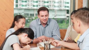 Sıradan tişörtlü zeki liseli çocuk, karışık ırkları olan öğrenciler kitap yazarken profesyonel öğretmene soruyor. Yaratıcı çocuk notayı işaret ederken Kafkas eğitmeni yorum yapıyor. Öğretim