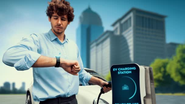 Бизнесмен Проверяет Состояние Аккумулятора Автомобиле Голограмме Smartwactch Подзарядке Зарядной Станции — стоковое видео