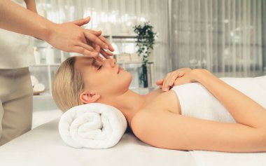 Kafkasyalı kadın stres önleyici kafa masajından ve lüks tatil beldesi ya da otel spa salonundaki modern ışık ortamında yüz güzelliği eğlencelerini şımartmaktan hoşlanıyor. Sessiz.