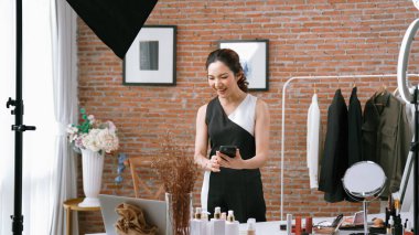 Kadın nüfuzlu kişi sosyal medya ya da blog için canlı yayın yapan video klip eleştirmeni derisini çekiyor. Canlı kozmetik stüdyosu ışıklandırması olan mutlu genç bir kız pazarlama için internet üzerinden yayın yapıyor..