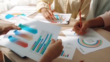 Girişimci şirket çalışanları birlikte çalışır, finansal veri raporlama ve planlama stratejisi, panorama videosundaki yaratıcı iş başarısı için pazarlama içeren renkli BI gösterge panelini analiz eder. Sinerjik