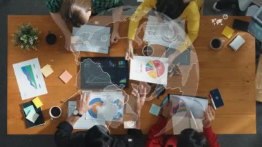 İletişim teknolojisi veya telekomünikasyon hologramı ile belgeye bakarken küresel ağ sistemi hakkında tartışan iş adamlarının yukarıdan aşağıya hava görüntüsü. Yaratıcı bir girişim. Cemaat.