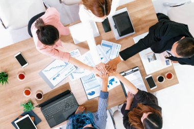 İş adamları ve iş kadınları, takım çalışması, destek ve iş birliğini gösteren çok kültürlü ofis odasındaki grup toplantılarında el ele tutuşuyorlar. Çeşitli işyerleri ve şirket çalışanları konsepti. uds