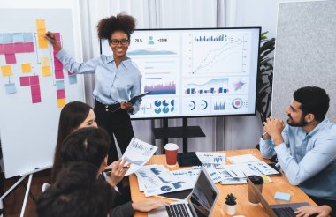 Genç Afrikalı iş kadını modern toplantıda TV ekranında veri analizi paneli sunuyor. Bir grup iş adamıyla konferans odasında iş sunumu. Uyum