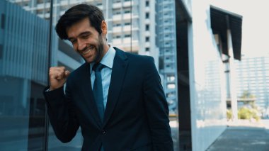 Cam duvarda yürürken neşeyle dans eden yetenekli bir iş adamı. Proje müdürü iyi haberler aldı, terfi aldı, başarılı bir iş buldu, aynı zamanda coşkuyu dile getirdi. Sevinçli..