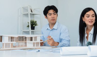 Kooperatif mühendis ekibinin portresi ev modelini ölçmek için cetvel ve mimari ekipmanlar kullanarak birlikte çalışıyor. Yaratıcı iş tasarımı ve takım çalışması konsepti. Tertemiz...