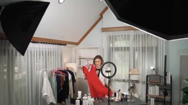 Kadın nüfuzlu kişi video görüntülerini canlı yayınlıyor. Kıyafetler sosyal medyada ya da blogda yer alıyor. Stüdyo ışıklandırmalı mutlu genç kız çevrimiçi pazarlama oturumu yayını için..