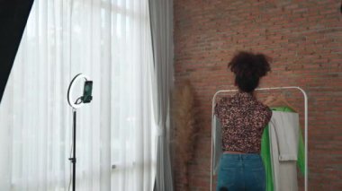 Arkadan bakıldığında kadın nüfuzlu kişi canlı yayın vlog görüntülerini çeker. Önemli sosyal medya ya da blogu gizler. Stüdyo ışıklandırmalı bir kız çevrimiçi pazarlama oturumu yayını için.