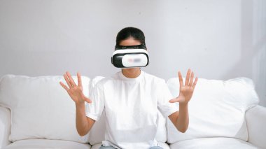 Canlı online alışveriş deneyimi için sanal gerçeklik gözlüğü kullanan genç bir kadın. Sanal gerçeklik VR yeniliği kadın dijital eğlence yaşam tarzı için optimize edildi.