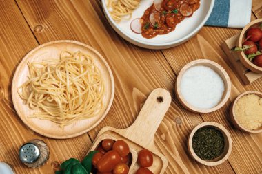 Lezzetli yiyecekler, ev yapımı spagetti, kıymalı domates sosu ve fesleğen fırlatma elementleri, şef masası dekoratif baharatlarla servis ediliyor. Varsayım.