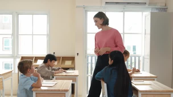 Sınıfta Çeşitli Çocuklar Sınıf Ödevlerini Yaparken Kafkasyalı Öğretmen Sınıfta Yürüyor — Stok video