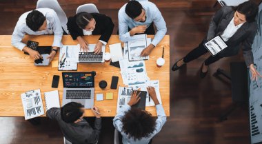 Modern toplantı odasındaki TV ekranında veri analizi paneliyle üst görünüm iş sunumu. İş adamlarının iş pazarlama stratejisini planlamak için beyin fırtınası yapması ya da birlikte çalışması. Uyum