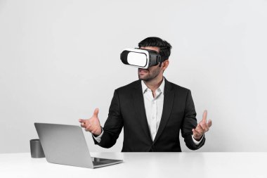 Bilgisayarla masada otururken ve VR gözlüğü takarken veri analizine bakan yetenekli bir iş adamı. Proje yöneticisi sanal gerçeklik sistemini kullanarak ya da metaevrende bağlantı kurarak çalışıyor. Sapma.