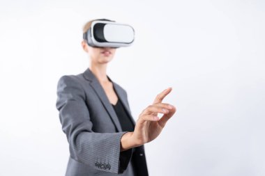 Profesyonel kadın lider programa dokunuyor ya da sanal gerçeklik gözlüğü kullanırken çalışıyor. Yetenekli iş kadını, görsel gerçeklik gözlüğü takarak metaevrene bağlanırken sistemi işaret ediyor. Kısıtlanma.