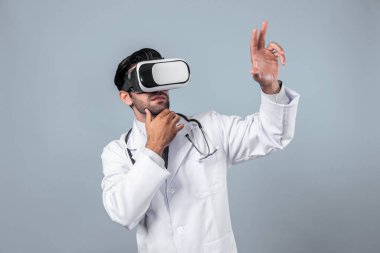 Profesyonel doktor tıbbi verileri inceliyor ve beyaz arka planlı VR gözlük ve laboratuvar önlüğü giyerken parmağıyla işaret ediyor. Kalifiye doktor ayakta ve tanı verileri. Teknoloji yeniliği. Sapma.