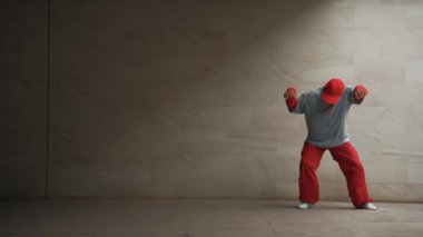 Profesyonel Asyalı hipster gri arka planlı break dansçı performansı sergiledi. Çekici bir sokak dansçısı şık kıyafetler giyerken hareketli hareketler yapar. Açık hava sporu 2024. Uzayı kopyala Yumuşak bir şekilde..
