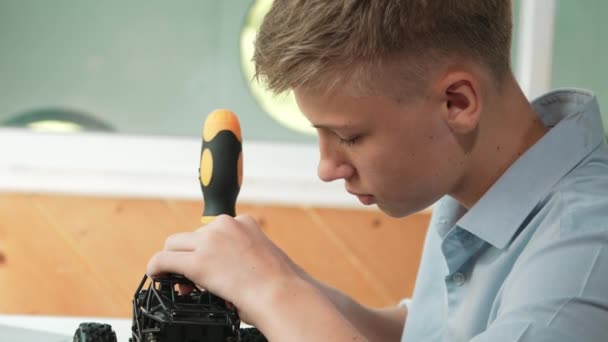 学生们用螺丝刀把螺母紧紧抓住 在Stem技术课上 白人青少年在检查机器人机器构造时修理或修理汽车模型 — 图库视频影像