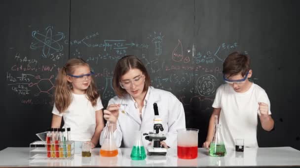 Biały Chłopiec Mieszający Płyn Chemiczny Podczas Gdy Nauczyciel Doradza Profesjonalny — Wideo stockowe
