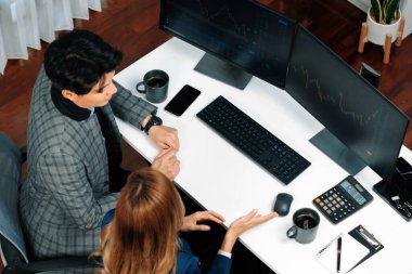 Başarılı Asyalı iş kadınının iş ortağı ile iş ortağı arasındaki dinamik borsa veri ekranına bakarak internet sitesi programını analiz etmenin en iyi görüntüsü. İnfobahn.