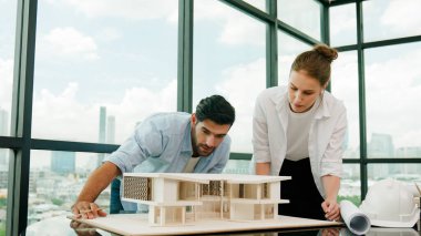 Kooperatif mimar mühendis ekibi kalem kullanarak ev modelini ölçmek için birlikte çalışıyor. Başarılı bir Kafkas iç mimari tasarım ekibi mimari model yapısını inceliyor. Tasarım. İzleme