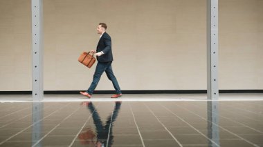 İş adamlarının bavul tutarken ve şehir merkezindeki iş yerine yürürken yan görüntüsü. Profesyonel proje yöneticisi dışarıda resmi takım elbise giyerken toplantıya gidiyor. Urbane.