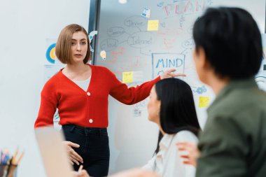 Kafkasyalı genç bir iş kadını, pazarlama stratejisini zihin haritası kullanarak sunuyor, soruları kendinden emin bir şekilde cevaplarken grafiğini çiziyor. Takım çalışması, beyin fırtınası, tartışma konsepti. Tertemiz..