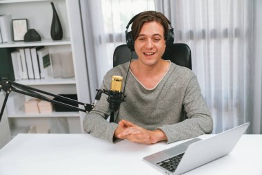 Sunucu kanalı, gülümseyen akıllı yayıncı kaydı, senaryosu ve akıllı telefonuyla sosyal medyada sohbet programı, kulaklık takarak modern ev stüdyosundaki video flamalarını kaydediyor. Bireysel.