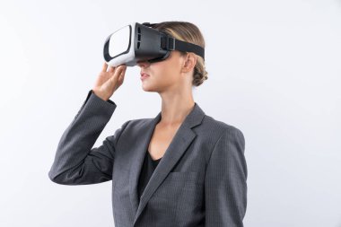 Yetenekli bir iş kadını arka planda dururken VR cam kullanarak görsel gerçeklik dünyasına bakıyor. Teknoloji yeniliklerini kullanarak metaevreni bağlamak için VR gözlüğü tutan akıllı bir yönetici. Kısıtlanma.
