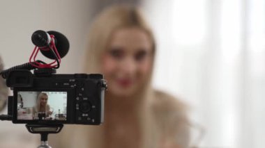 Güzellik ve kozmetik öğretim videosu içeriği yapan kamera görüntüsü kadını ya da perde arkası görüntüsü. Güzellik blogcusu izleyicilere ya da sosyal medya takipçilerine güzellik hizmetinin nasıl uygulanacağını gösteriyor. Blithe