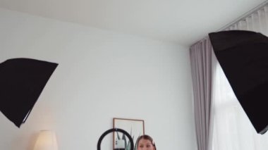 Sosyal medya için güzellik ve kozmetik video içeriği hazırlayan genç bir kadın. Güzellik blogcusu kameraya gülümserken seyircilere ve takipçilere güzellik bakımını gösteriyor. Düzenle