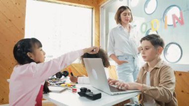 Akıllı öğretmen öğrencilere elektrikli aletin bir kısmını açıklamak için cam tahta kullanıyor. Çeşitli çocuklar elektronik aletleri öğrenir ve ana kartı ya da robotu tamir ederken dizüstü bilgisayar kullanır. Etkinlik.