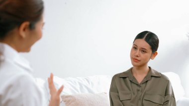 Psikologla ruh sağlığı terapisi gören üzgün travma sonrası stres bozukluğu olan bir kadın. Yaşam sonrası depresyon veya keder. Hayal kırıklığına uğramış genç bir kadın klinikteki duygular hakkında Vivancy psikoloğuyla konuşuyor.