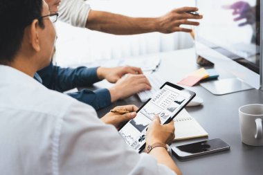 Veri analistleri ofis çalışanlarından oluşan bir ekip, tablet kullanarak finansal, trend ve pazarlama verilerini analiz etmek için iş istihbaratı BI gösterge paneli üzerinde işbirliği yapmaktadır. BI teknolojisi ve veri analizi kavramı. Tedbirli