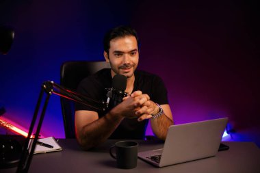 Yayıncı, fanclub dinleyicisiyle mikrofon kullanarak konuşuyor. Mor neon ışıklı modern stüdyoda yaratıcı olumlu düşünce konseptiyle canlı yayında finansal sorunları tartışıyor. Tahmin et..