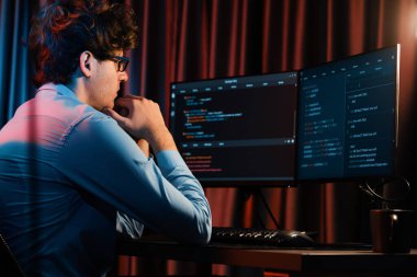Uygulama pc ekranları ile çevrili çevrimiçi yazılım geliştirme bilgilerini yoğunlaştıran IT geliştiricisi, neon modern ofis evindeki web sitesinde yazılım için program yaratıyor. Toplayıcı.