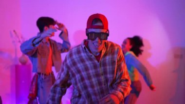 Çekici dansçı hip hop müzik eşliğinde çeşitli arkadaşlarıyla dans ediyor ve performansını destekliyor. Stüdyoda neon ışıklı şık kıyafetler giyen profesyonel çok kültürlü insanlar. Mutluluk.