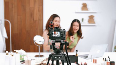 Etkilenen iki ortak canlı yayın yapan video görüntülerini sosyal medya ya da blog üzerinden gözden geçirir. Canlı kozmetik stüdyosu ışıklandırması olan mutlu genç bir kız pazarlama için internet üzerinden yayın yapıyor..