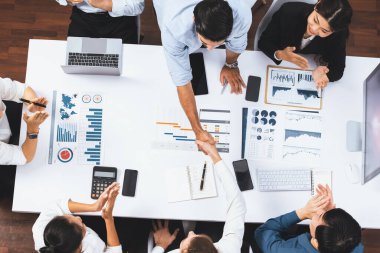 Üst düzey ofis çalışanları stratejik iş pazarlama toplantısı üzerine anlaşma yaptıktan sonra el sıkışıyor. Takım çalışması ve olumlu tutum verimli ve destekleyici bir iş yeri yaratır. Tedbirli