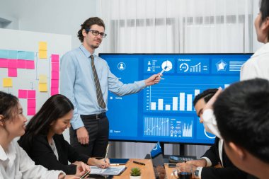 İş adamı, finansal rapor veri analizi veya pazar eğilimi gösterisiyle iş sunumunu şirketin gelecekteki yönetiminde stratejik planlama için büyük bir TV ekranında sundu. Habiliment