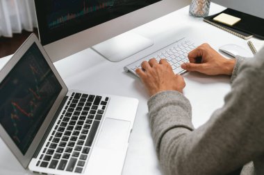 Gündelik işlerde çalışan kıyılmış işadamı, modern ofisteki bilgisayar ekranında borsa borsa veritabanını analiz ederek sunum için iş pazarlama raporunu araştırmak için bilgisayarı kullanıyor. Bireysel.