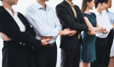 Mutlu ve gülümseyen çok ırklı ofis çalışanı, sinerjiyi ve ticari başarı için işbirliğini destekleyen bir kuyrukta el ele tutuşuyor. Modern işyerinde çeşitli profesyonel ofis çalışanları arasında bağ var. Uyum