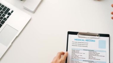 Hasta klinikte ya da hastane ofisinde doktor randevusuna gidiyor. Hastaların risk faktörünü tespit etmek için nabzını elle kontrol ederken doktor semptomları inceliyor ve teşhis ediyor. Ağır çekim. Katı.