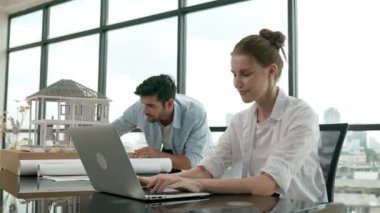 Meslektaşına ev tasarımından bahsederken profesyonel mühendis ölçüm modeli. Laptop analiz verilerini kullanan zeki genç bir mimar. İç işleri ekibi gökdelen ile birlikte çalışıyor. İzleme