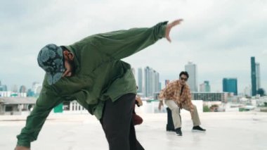 Profesyonel break dans takımı çatıda çok kültürlü arkadaşlar varken break dans alıştırması yapıyor. Genç modern dans grubu hip hop hareketi yapıyor. Tarz, moda, aksiyon. Açık hava sporu 2024 hiphop..